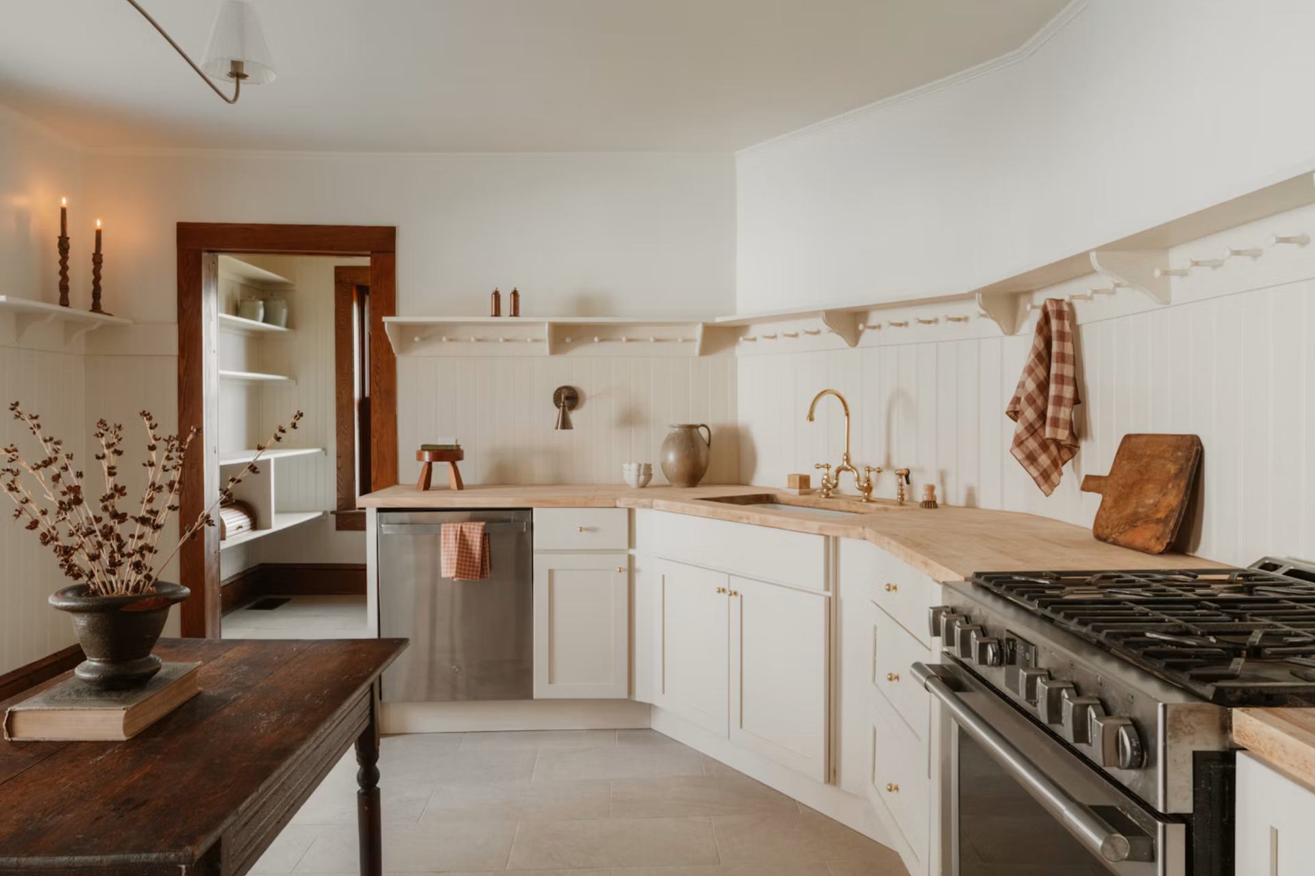 A calm, tidy kitchen with cream cabinets and a wooden counter